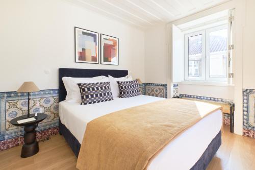 a bedroom with a large bed and a window at Ando Living - Santa Justa 79 House in Lisbon
