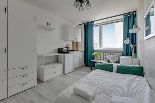 a white bedroom with a bed and a window at Gdynia Campus in Gdynia