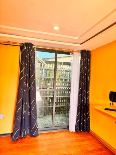 a room with a window with black and white curtains at MERAKI BEACH RESORT Lodges in Lomé