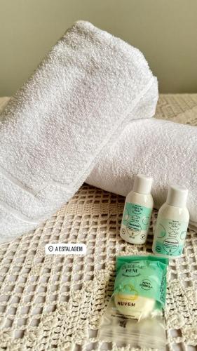 a towel and two bottles of toothpaste on a bed at A Estalagem Pousada in Monteiro Lobato