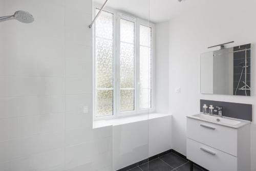 une salle de bain blanche avec une douche et un lavabo dans l'établissement Kenavo, à Brest