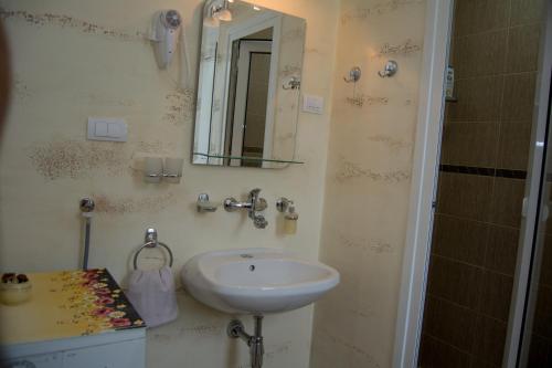 a bathroom with a sink and a mirror at Guest House A'storia in Ruma