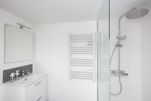 une salle de bain blanche avec une douche et un lavabo dans l'établissement Pokou, à Brest