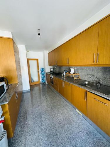 a kitchen with wooden cabinets and a sink at Big House in Vila Nova de Gaia