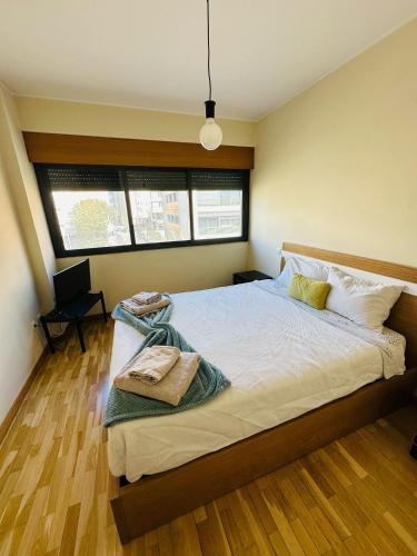 a bedroom with a large bed with two windows at Big House in Vila Nova de Gaia