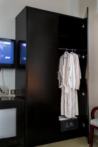 a black wardrobe with a white shirt and a tv at FARS Hotel & Resorts - BAR-Buffet-Pool-SPA in Dhaka