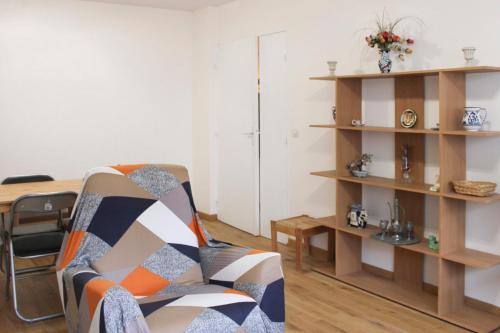 un salon avec une chaise et une table dans l'établissement Lovely 1-bedroom apartment near park, à Pantin