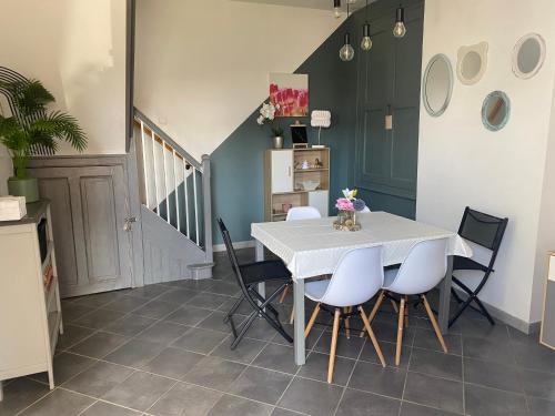 une salle à manger avec une table et des chaises blanches dans l'établissement maison cosy, à Cambrai