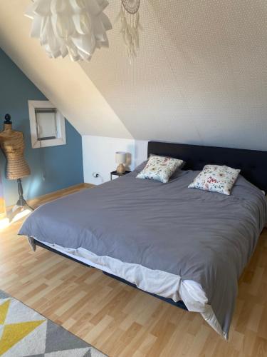 une chambre avec un grand lit avec deux oreillers dans l'établissement maison cosy, à Cambrai