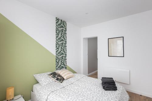 une chambre avec un lit et un mur dans l'établissement Friskette, à Brest