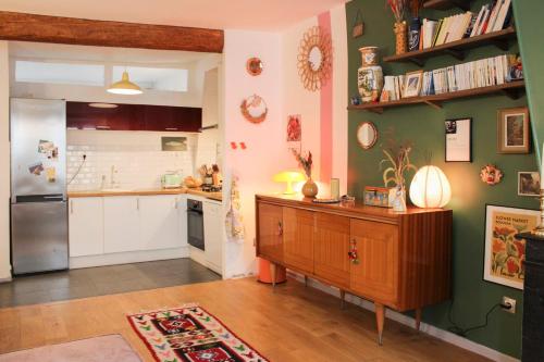 La cuisine est équipée d'un réfrigérateur et d'une armoire en bois. dans l'établissement Charming Parisian Stay Just Steps from Montmartre, à Paris