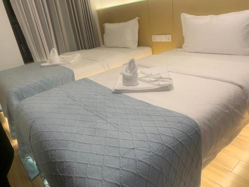 two beds in a hotel room with shoes on them at Amanda Hotel堆谷里酒店 in Phnom Penh
