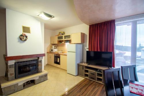 a kitchen with a refrigerator and a tv in a room at Ski Chalets at Pamporovo - an affordable village holiday for families or groups in Pamporovo