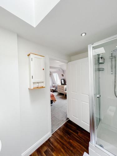 a bathroom with a shower and a glass door at Town Centre Apartment in Berwick-Upon-Tweed