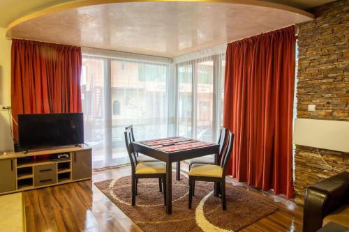 a dining room with a table and chairs and a television at Ski Chalets at Pamporovo - an affordable village holiday for families or groups in Pamporovo