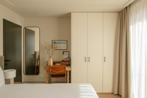 リスボンにあるPOSTCODE Liberdadeのベッドと机と鏡のある寝室