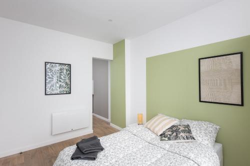 une chambre avec un lit et un tableau au mur dans l'établissement Tomm, à Brest