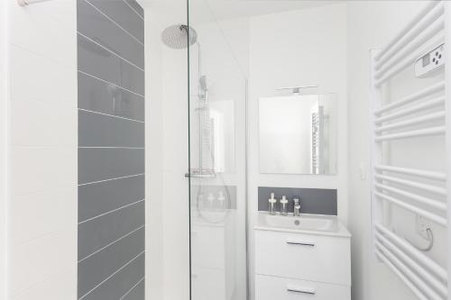 une salle de bain blanche avec une douche et un lavabo dans l'établissement Tomm, à Brest