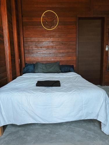 a large white bed with a wooden wall at Rustika in Holbox Island