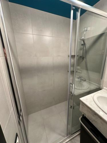 a shower with a glass door in a bathroom at BATUMI VIEW, appartaments 50 metres from sea in Batumi