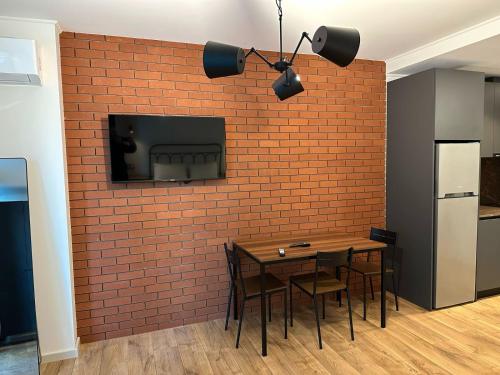 a dining room with a brick wall and a table and chairs at BATUMI VIEW, appartaments 50 metres from sea in Batumi