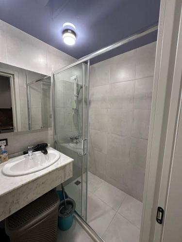 a bathroom with a sink and a glass shower at BATUMI VIEW, appartaments 50 metres from sea in Batumi