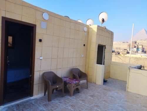 开罗apartment pyramids view的大楼内的房间,配有两把椅子和一张桌子
