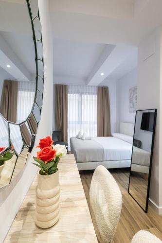 a living room with a bed and a vase with flowers at Primat Reig flats in Valencia