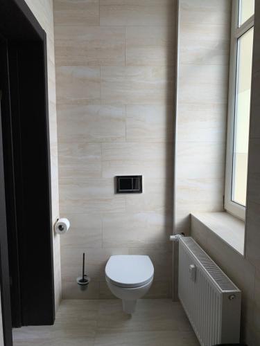 a small bathroom with a toilet and a window at Sweet Apartments in Šiauliai