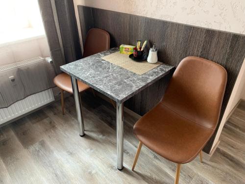 a table with two chairs and a counter top at Sweet Apartments in Šiauliai