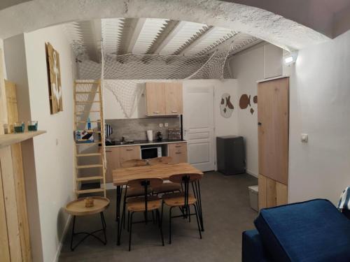 une cuisine avec une table et des chaises dans une pièce dans l'établissement La Cabine du Large 1, à Montélimar