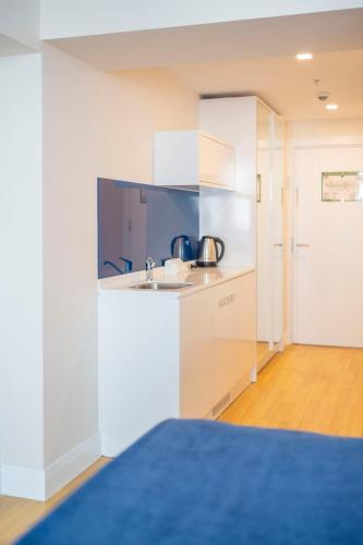 a kitchen with white cabinets and a sink at Orbi City Hotel D1 Block in Batumi