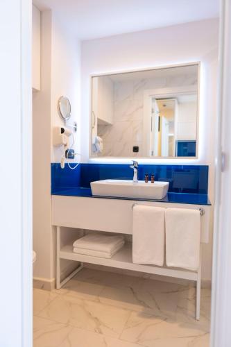 a bathroom with a sink and a mirror at Orbi City Hotel D1 Block in Batumi