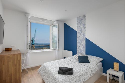 une chambre avec un lit et une grande fenêtre dans l'établissement Big aille, à Brest