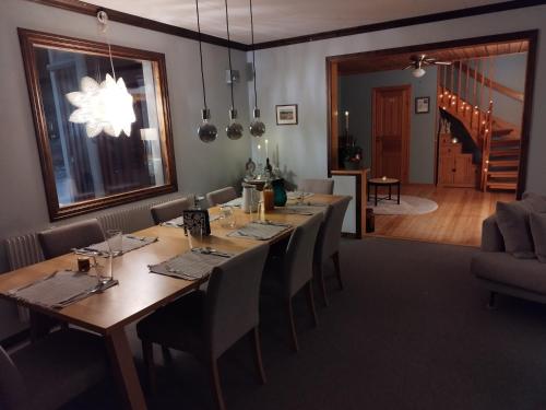 a dining room with a long wooden table and chairs at Wild Power Guesthouse in Lycksele
