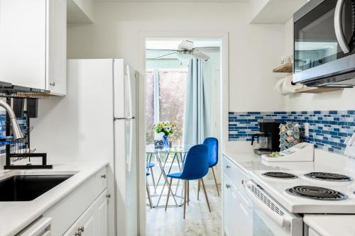 a kitchen with white counters and blue tiles at Fresh & Comfy House with Hot Tub, Pool Table, & BBQ in Eugene