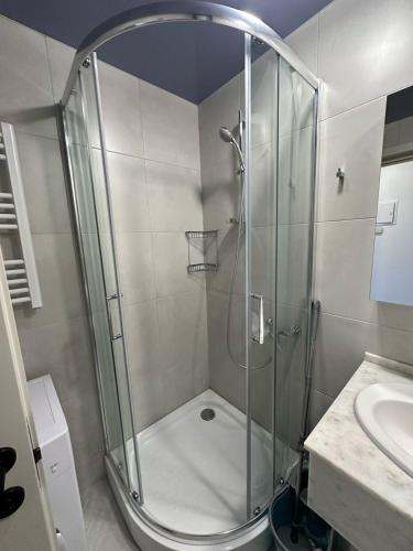 a shower with a glass door in a bathroom at BATUMI VIEW, appartaments 50 metres from sea in Batumi