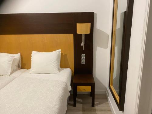 a bedroom with a bed and a table with a mirror at Discovery Apartment Carnaxide in Carnaxide