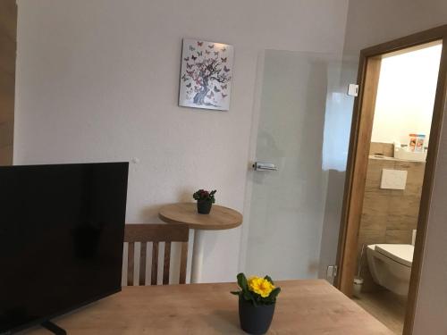 ein Wohnzimmer mit einem Tisch und einem TV in der Unterkunft Hotel am Wasserturm in Crailsheim