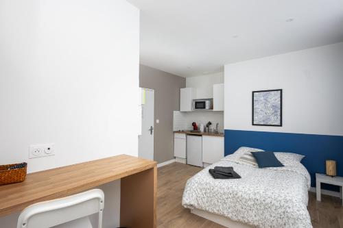 une chambre avec un lit et un bureau dans l'établissement Ma Doue, à Brest