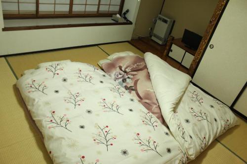 a bed with a blanket on the floor in a room at Nozawa Dream in Nozawa Onsen