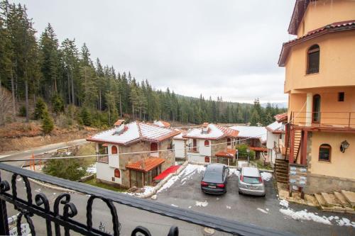a group of buildings with cars parked in a parking lot at Ski Chalets at Pamporovo - an affordable village holiday for families or groups in Pamporovo