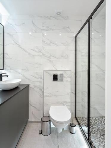 a white bathroom with a toilet and a sink at Apartments in the old town in Vilnius
