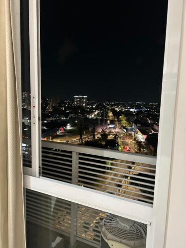 a window with a view of a city at night at Diamond Flat Aparthotel Mont Blanc in Nova Iguaçu