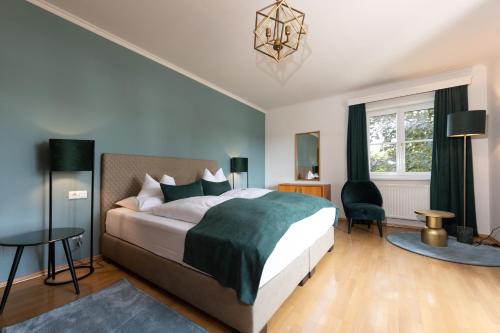 a bedroom with a bed and a chair and a window at Parkvilla 11 in Fürstenfeld