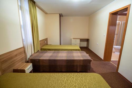 a room with two beds and a mirror at Ski Chalets at Pamporovo - an affordable village holiday for families or groups in Pamporovo