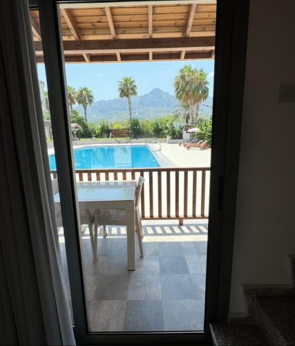 a view of a balcony with a table and a pool at The Horse Farm Hotel in Kérynia
