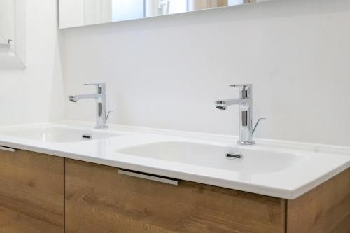 une salle de bain avec deux lavabos et un miroir dans l'établissement Belle maison de vacances avec piscine - 8 personnes, à Les Sables-dʼOlonne