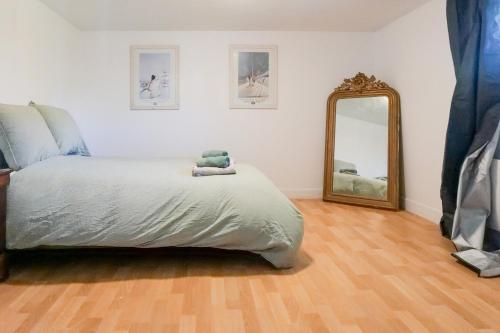 une chambre avec un grand lit et un miroir dans l'établissement Belle maison de vacances avec piscine - 8 personnes, à Les Sables-dʼOlonne
