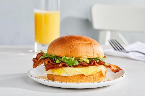 a chicken sandwich on a plate with a glass of orange juice at Courtyard Baltimore Downtown/McHenry Row in Baltimore